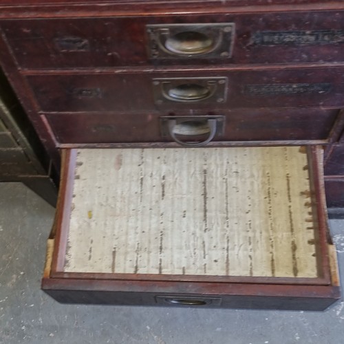 5 - A late Victorian mahogany haberdashery shop bank of fourteen drawers, each graduated drawer with flu... 