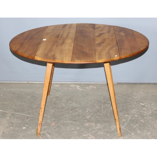 1 - A retro blonde Ercol dropleaf dining table, approx 141cm x 72cm when folded down, bearing partial la... 