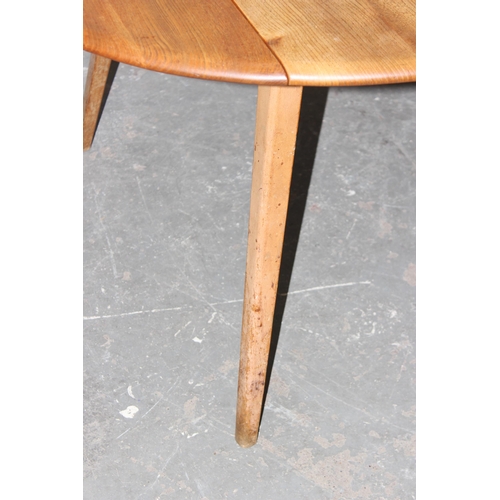 1 - A retro blonde Ercol dropleaf dining table, approx 141cm x 72cm when folded down, bearing partial la... 