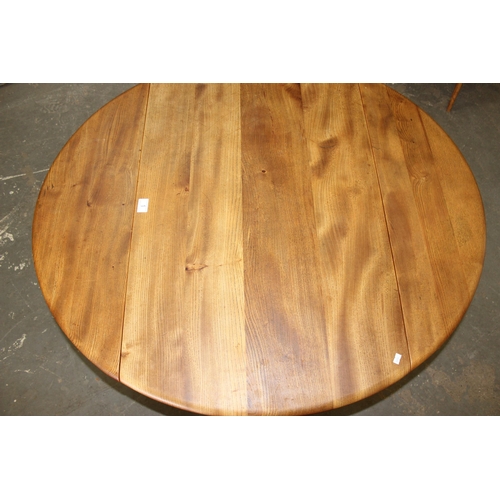 1 - A retro blonde Ercol dropleaf dining table, approx 141cm x 72cm when folded down, bearing partial la... 