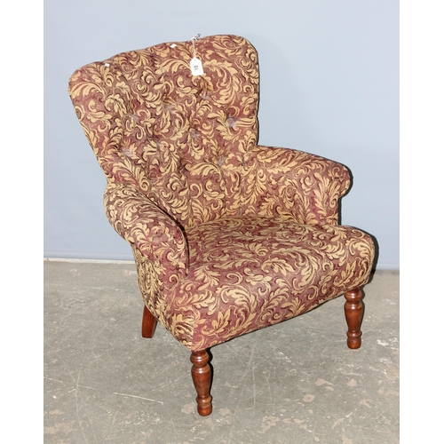 10 - A Victorian style low button backed armchair with decorative acanthus scrolled designed upholstery