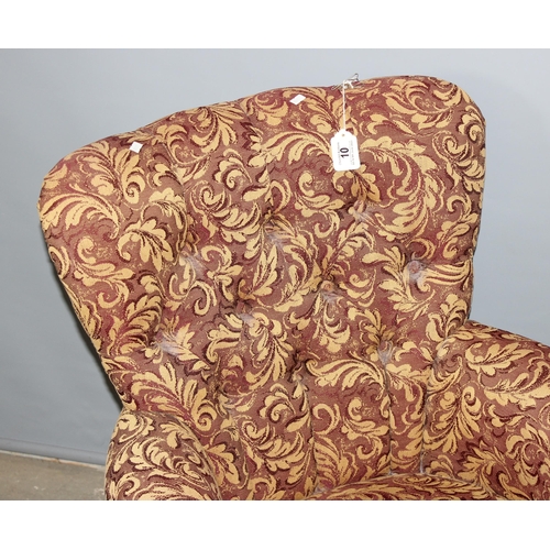 10 - A Victorian style low button backed armchair with decorative acanthus scrolled designed upholstery