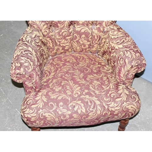 10 - A Victorian style low button backed armchair with decorative acanthus scrolled designed upholstery