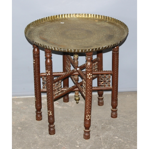 28 - A vintage brass topped Benares table with folding wooden and inlaid base, approx 59cm in diameter