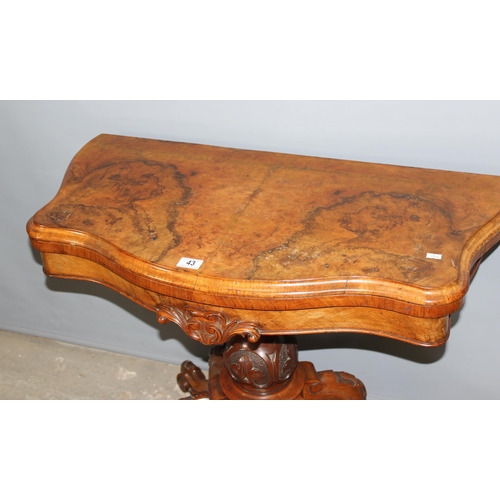 43 - A 19th century walnut folding card table with deep carved details, standing on carved pillar stand a... 