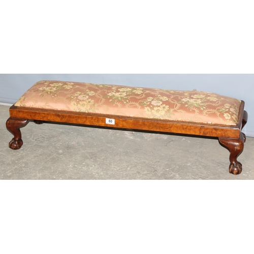 60 - An antique long low stuffed and upholstered foot stool standing on ball and claw feet, approx 100cm ... 