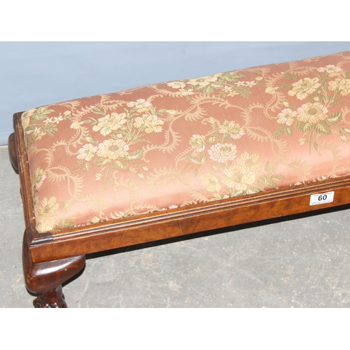 60 - An antique long low stuffed and upholstered foot stool standing on ball and claw feet, approx 100cm ... 