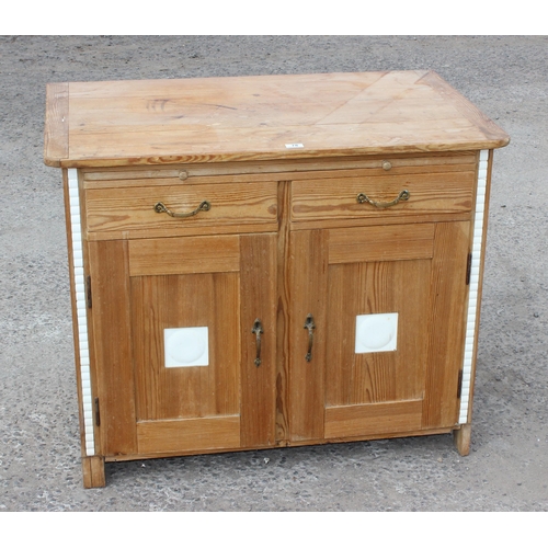 78 - An antique pine sideboard or cabinet with 2 doors under 2 drawers and a single slide, set with moder... 