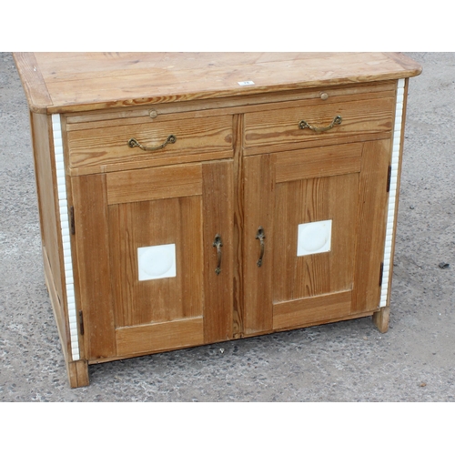 78 - An antique pine sideboard or cabinet with 2 doors under 2 drawers and a single slide, set with moder... 