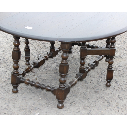 128 - An Ercol dark finish drop leaf table with bobbin turned legs, approx 106cm x 92cm