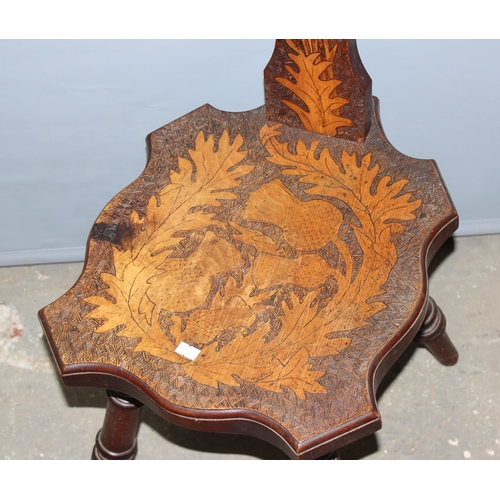 141 - An early 20th century Scottish pokerwork spinning chair decorated with thistles, approx 97cm tall