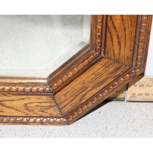 407 - An early 20th century oak framed elongated octagonal mirror, approx 65cm x 43cm