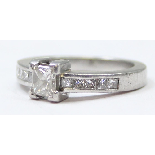 1151A - A Platinum ring set with a large central square Princess cut diamond and flanked with 5 similar squa... 