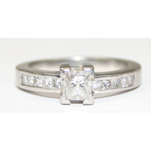 1151A - A Platinum ring set with a large central square Princess cut diamond and flanked with 5 similar squa... 