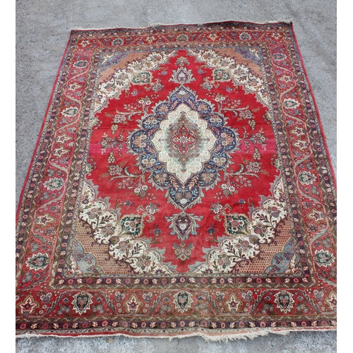 205 - A large decorative red ground rug with arabesque border, approx 400cm x 290cm