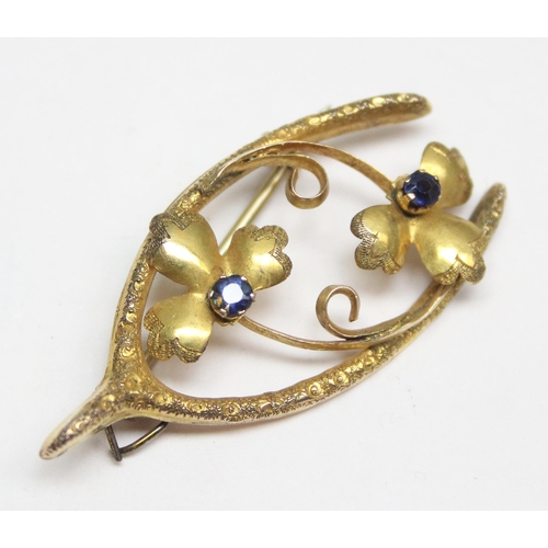 1150 - An Art Nouveau period 9ct gold wishbone brooch set with garnets (sic Sapphires), approx 2.02g gross