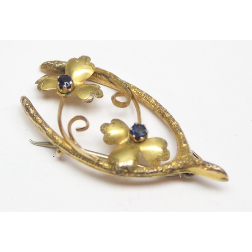 1150 - An Art Nouveau period 9ct gold wishbone brooch set with garnets (sic Sapphires), approx 2.02g gross