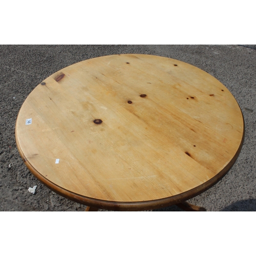 149 - Round pine kitchen table on three-legged base approx 110cm in diameter, 78cm high