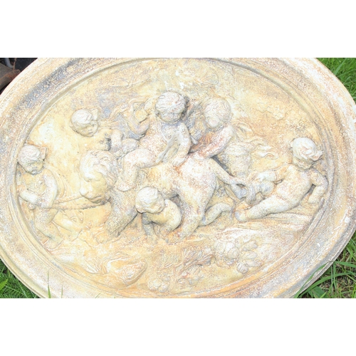 319 - A garden wall plaque depicting cherubs with a lion, approx 58cm wide