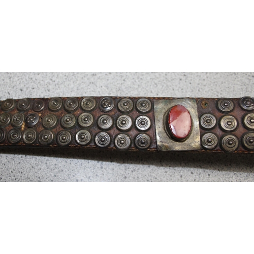 1648 - An unusual antique studded leather belt set with cabochon bloodstones, the unmarked white metal moun... 