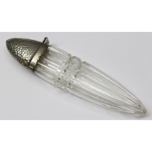 1073 - An antique scent bottle of unusual form with facet cut glass body and hammered silver plated top, ap... 