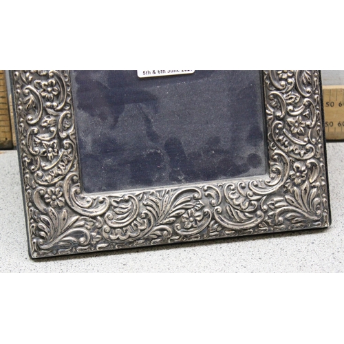 1080 - A large antique style embossed silver photograph frame, London 2000 by JC, approx 29cm x 21cm