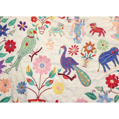 211 - An Early 20th century Indian Toran, embroidered in bright colours with figures and animals and Ganes... 