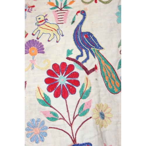 211 - An Early 20th century Indian Toran, embroidered in bright colours with figures and animals and Ganes... 