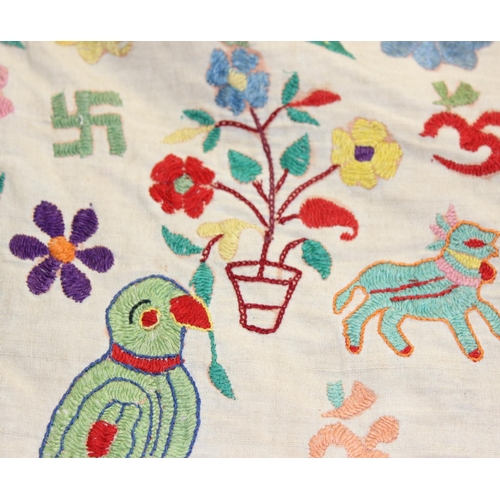 211 - An Early 20th century Indian Toran, embroidered in bright colours with figures and animals and Ganes... 