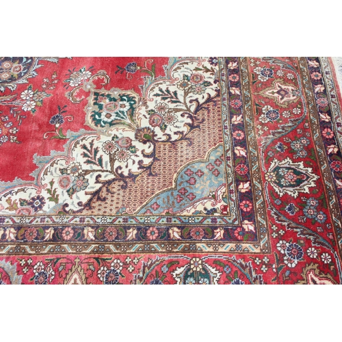 205 - A large decorative red ground rug with arabesque border, approx 400cm x 290cm