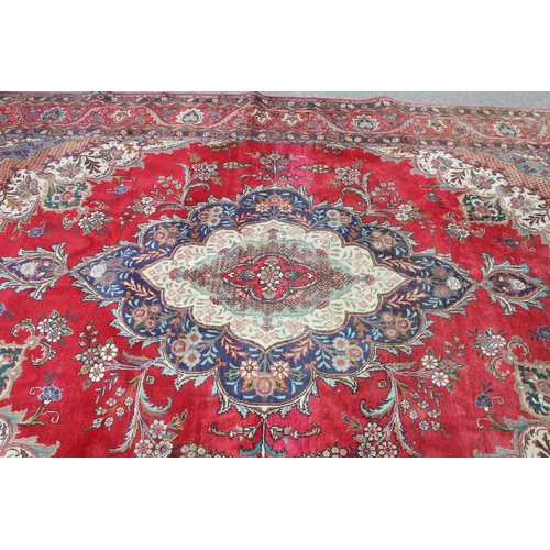 205 - A large decorative red ground rug with arabesque border, approx 400cm x 290cm