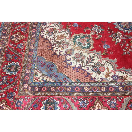 205 - A large decorative red ground rug with arabesque border, approx 400cm x 290cm