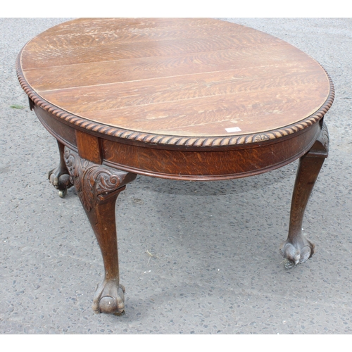 47 - An early 20th century oak wind out dining table with impressively carved paw feet and rope twist bor... 