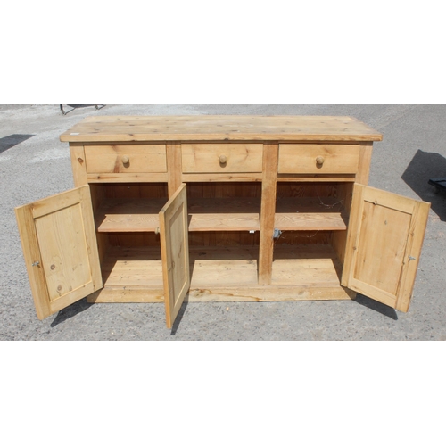 23 - A 20th century pine farmhouse kitchen dresser, 3 drawers over 3 cupboards with 5 short drawers on to... 