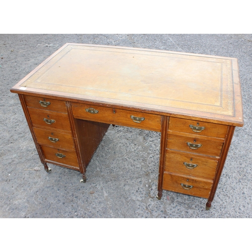 7 - An early 20th century leather topped desk with a long central drawer and 2 banks of 4 drawers with b... 