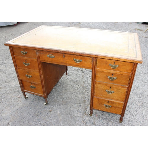 7 - An early 20th century leather topped desk with a long central drawer and 2 banks of 4 drawers with b... 