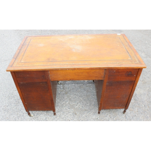 7 - An early 20th century leather topped desk with a long central drawer and 2 banks of 4 drawers with b... 