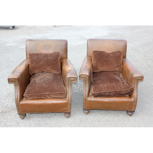 17 - A pair of Art Deco period brown leather or leatherette library chairs with studded decoration and ca... 