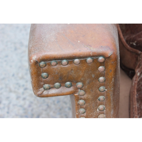 17 - A pair of Art Deco period brown leather or leatherette library chairs with studded decoration and ca... 