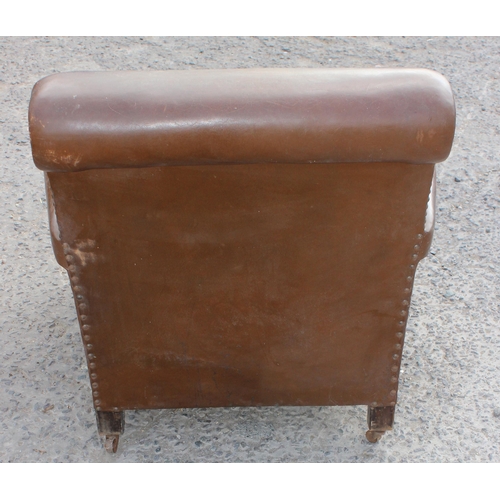 17 - A pair of Art Deco period brown leather or leatherette library chairs with studded decoration and ca... 