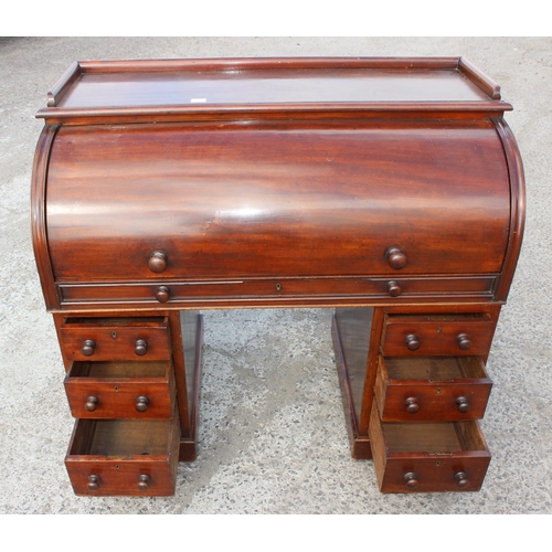 9 - A Victorian mahogany cylinder desk, the roll top concealing six drawers and five pigeon holes, the p... 