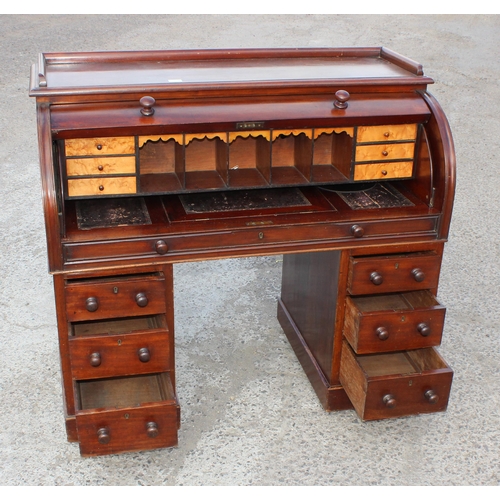 9 - A Victorian mahogany cylinder desk, the roll top concealing six drawers and five pigeon holes, the p... 