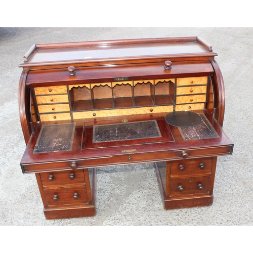 9 - A Victorian mahogany cylinder desk, the roll top concealing six drawers and five pigeon holes, the p... 