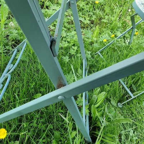 312 - A metal garden bistro set with 2 chairs, the table and chairs with colourful glazed pottery inserts,... 