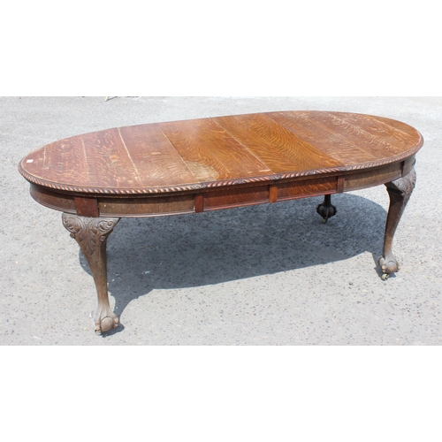 47 - An early 20th century oak wind out dining table with impressively carved paw feet and rope twist bor... 