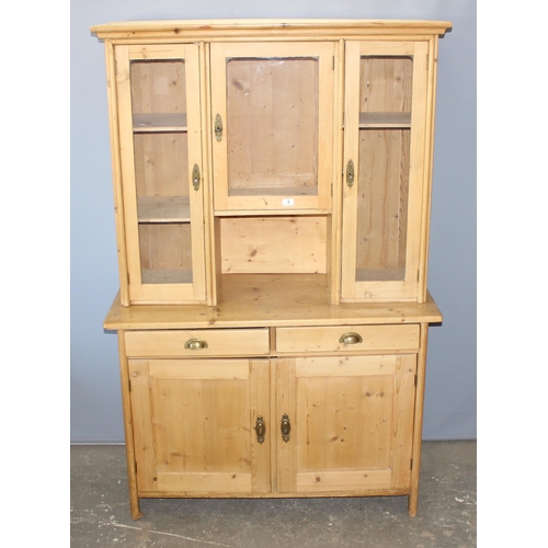 4 - A large antique pine kitchen dresser with 3 glazed doors over 2 drawers with brass cup handles over ... 