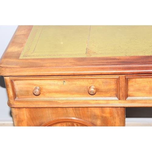 64 - A Victorian mahogany pedestal desk with 3 drawers over 2 cupboards, one cupboard containing a bank o... 