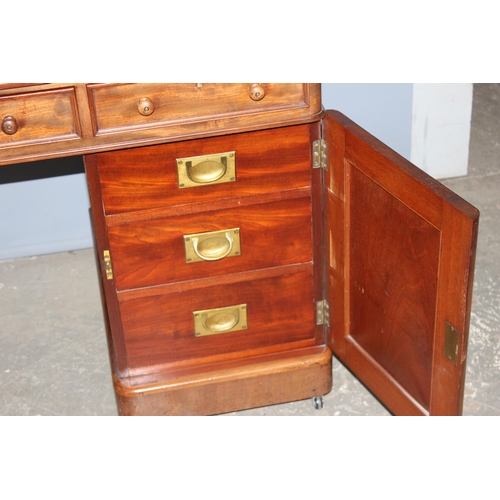 64 - A Victorian mahogany pedestal desk with 3 drawers over 2 cupboards, one cupboard containing a bank o... 