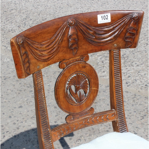 102 - An early 19th century rail back mahogany dining chair with carved swag details.