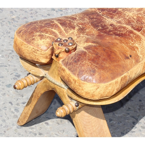 107 - A vintage leather and wooden camel stool, approx 53cm wide x 32cm tall x 33cm deep